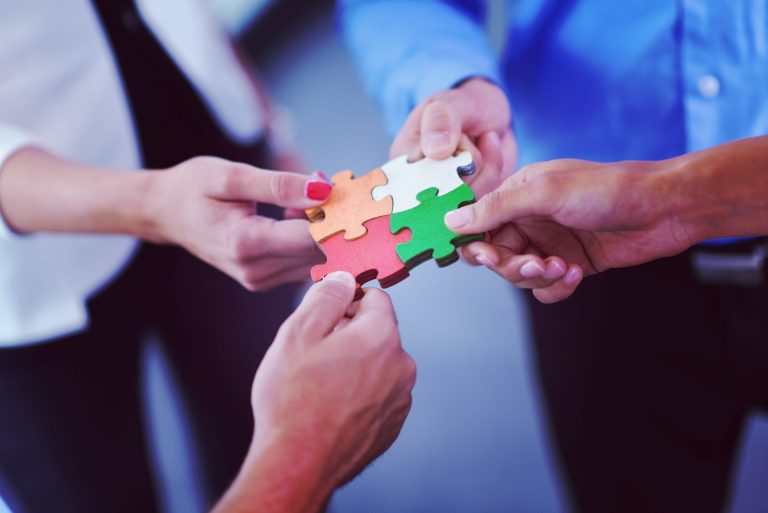 group of business people assembling jigsaw puzzle PC53NT9 scaled 1
